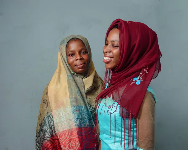 Two happy African Nigerian female muslim sisters or friends with Hijab scarves, prepared to engage the process of prayer or ablution which is more noticeable during ramadan and when going to mosque