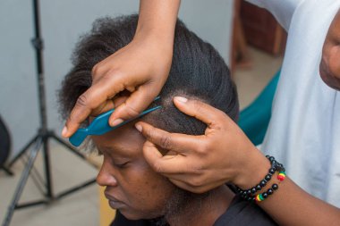 Hands of an hairdresser, stylist or entrepreneur making hair for a female customer in a salon