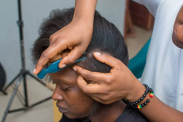 Hands of an hairdresser, stylist or entrepreneur making hair for a female customer in a salon