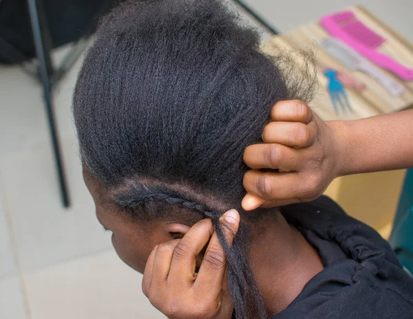 Hands of an hairdresser, stylist or entrepreneur making hair for a female customer in a salon