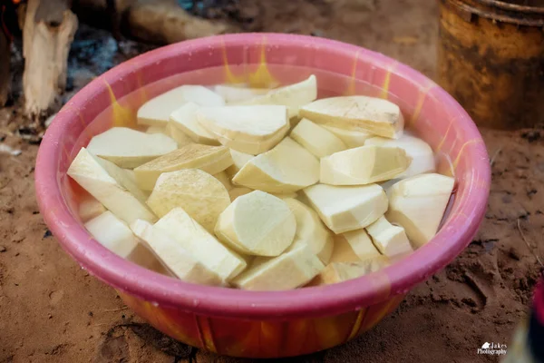 Nijerya mutfağında yemek pişirmeye hazır olmak için bir kova suyun içine yerleştirilmiş patatesler.