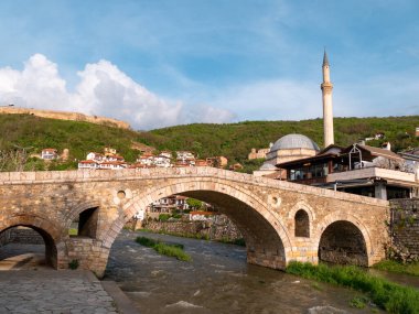Kosova 'nın Prizren kentindeki eski Osmanlı köprüsü ve camii gün batımından hemen önce