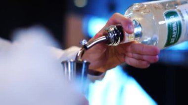 Barmen bardağa kokteyl dolduruyor.