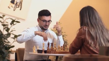 Satranç müsabakaları sırasında satranç tahtasındaki bir sonraki hamlenin taktik stratejisi üzerinde düşünen erkek ve kadın. Genç çift boş zamanlarında favori oyunlarında oynuyorlar.