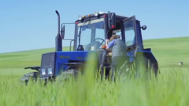 畑のトラクター 古い農家はトラクターから降りる — ストック動画