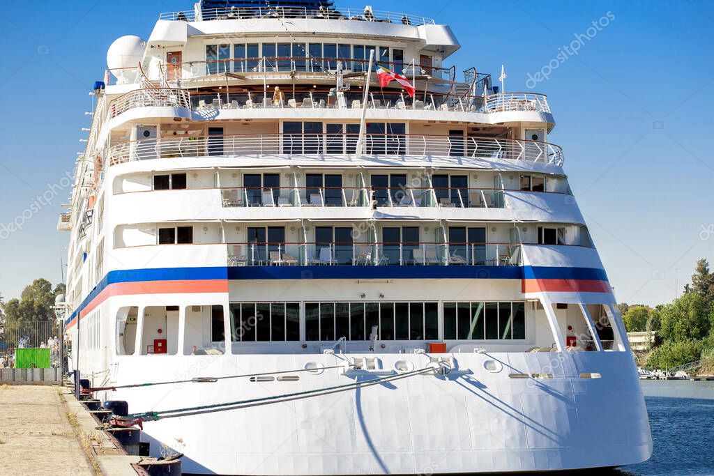 Luxury cruise ship docked in port. Front view of white passenger vessel.
