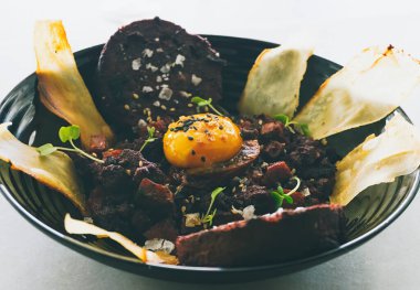 Kanlı sosis ve kurutulmuş sucuklu tartar, edamame ve soya yumurtasına sarılmış yumurta.