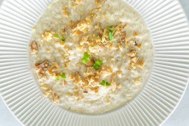 Lezzetli ve kremalı risotto peynirli ve beyaz tabakta ceviz. Üst görünüm ve kapatma 