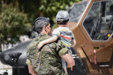 Seville, İspanya - 30 Mayıs 2019: İspanya 'nın Sevilla kentinde İspanyol Silahlı Kuvvetleri Günü sırasında küçük bir çocukla birlikte Helicopter HA.28 Tiger' ı izleyen asker