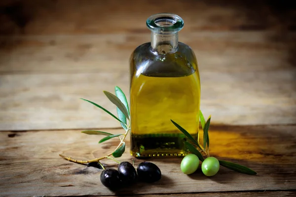 Olive oil and olive branch on the wooden table