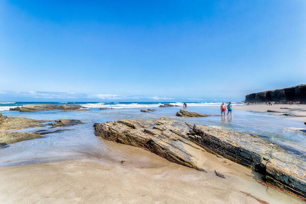 Ribadeo, Spain - August 21 2019: Cathedrals beach. Designated a Natural Monument, is one of the most famous beaches in Galicia. It is known around the world for its rocky formations carved by the wind and sea.