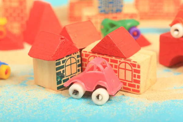 toy house with toys on the wooden background