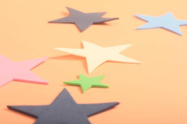 Pembe arka planda farklı şekillerde yıldızlar.