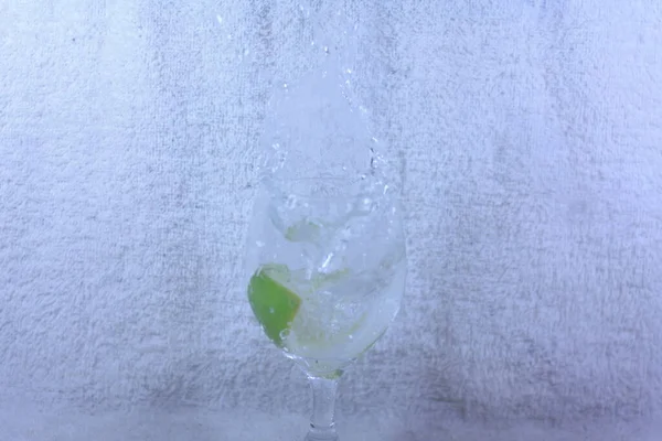a glass of water with lime and ice-shaped in a transparent cup on an isolated background.
