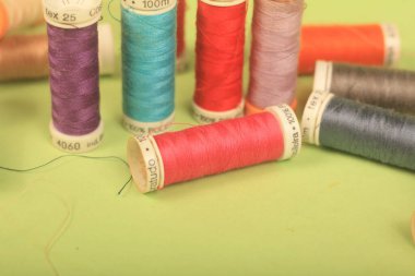 Yeşil arkaplanda iplikler dikiliyor