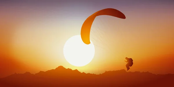 Concept of extreme sport in the middle of a mountain landscape, with a paraglider flying at sunset.