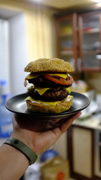 Siyah tabakta iki pirzola ve sığır etli burger.
