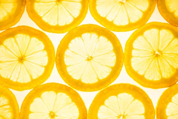 Fresh lemon slices translucent flat lay background.