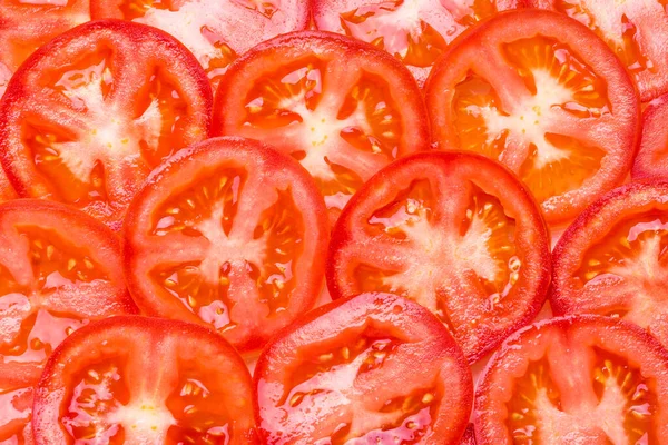 Tomatoes slices close up background.