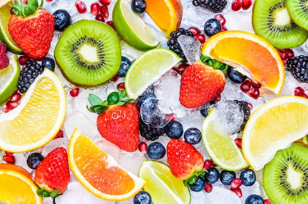 Fresh fruits background.Slices of fresh fruits top view on ice.