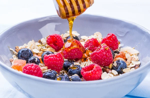 Healthy breakfast bowl with cereals oats and fruits and honey.