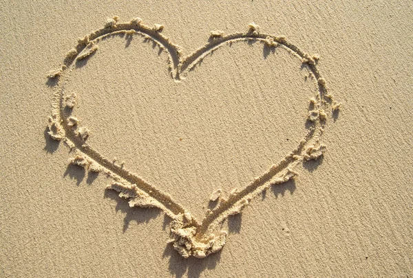 Drawing heart on sand beach background copy space.