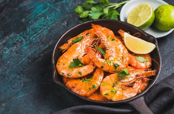 Shrimps stir-fried or roasted tasty argentine jumbo shrimps in pan copy space dark background.