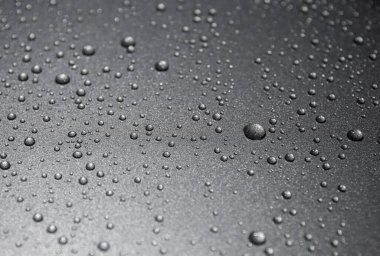 Siyah arkaplanda su damlaları var.