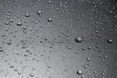 Siyah arkaplanda su damlaları var.