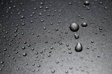 Siyah arkaplanda su damlaları var.