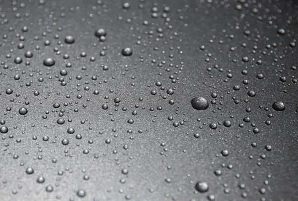 Siyah arkaplanda su damlaları var.