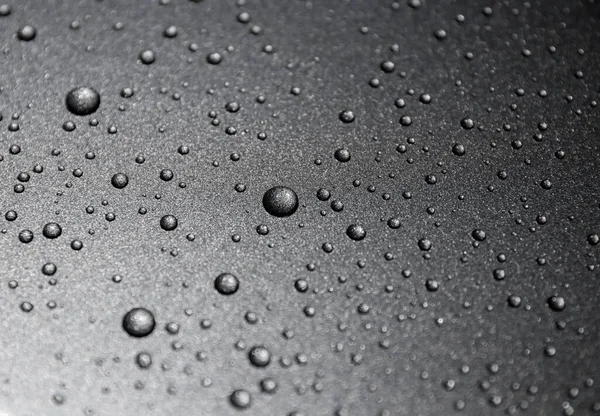 Siyah arkaplanda su damlaları var.