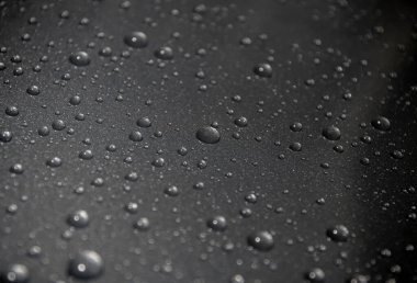 Siyah arkaplanda su damlaları var.