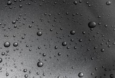 Siyah arkaplanda su damlaları var.