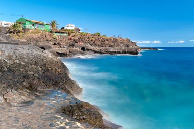 La Caleta, El Hierro, Kanarya Adaları, İspanya 'da mavi deniz ve kırsal yüzme alanları olan güzel bir volkanik sahilin uzun pozu..