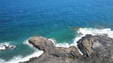 Mavi bir okyanus manzarasının ve El Hierro 'nun volkanik kıyılarının kırılan dalgaları ve sualtı yapılarının insansız hava aracı görüntüleri.