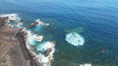 Kanarya Adaları, El Hierro, İspanya 'da kayalık bir plajda dalgalanan volkanik bir kıyı şeridinin manzaralı manzarası..
