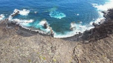 İspanya 'nın Kanarya Adaları, El Hierro, kayalık bir plajda, sarp kayalıkları ve okyanus dalgaları olan volkanik bir sahil görüntüsü..