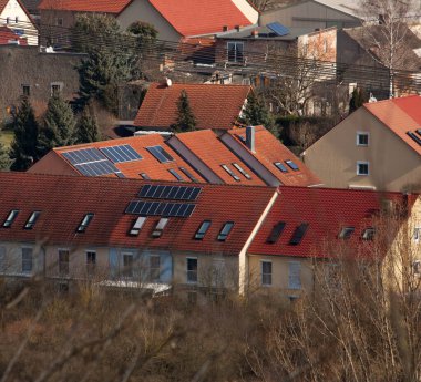 Güneşte güneş panelleri olan birden fazla ev.