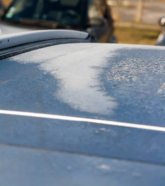 frozen roof of a car in the sun, defrosting & melting in the sun