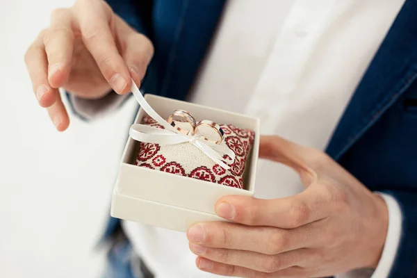 Groom Holds Gold Wedding Rings Decorative Box Small Pillow Ribbons — Stock Photo, Image