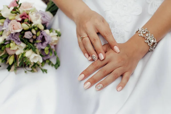 スタイリッシュな白いウェディングドレスで花嫁 近くには色とりどりの花の花束があります — ストック写真
