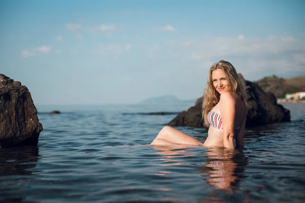 Uzun Saçlı Sarışın Bir Kız Çizgili Mayo Giymiş Okyanusun Kenarında — Stok fotoğraf