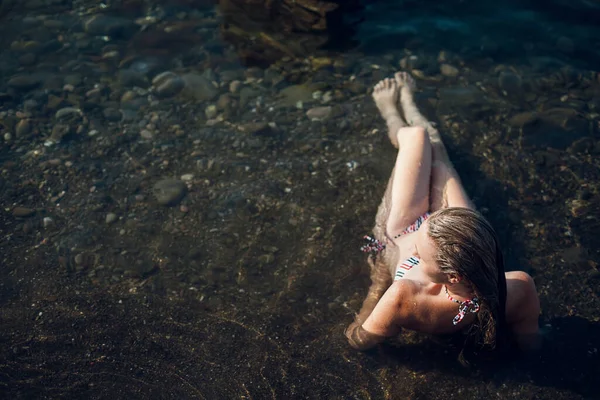 Blonde Girl Long Hair Striped Swimsuit Ocean Sits Rocks Water — Stock Photo, Image