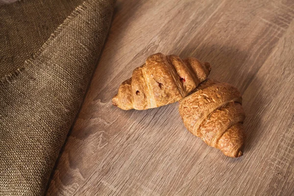 Dois Croissants Grandes Apetitosos Encontram Uma Tabela Texturizada Madeira Marrom — Fotografia de Stock