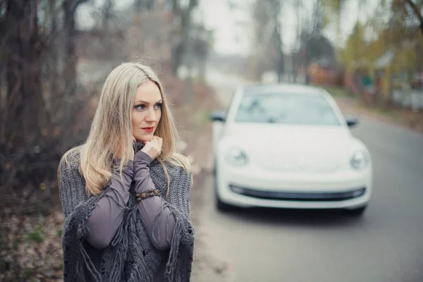 금발의 아름다운 소녀가 구름낀 자동차 사진입니다 — 스톡 사진