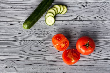 Mutfaktaki açık ahşap bir masada domates ve salatalık dilimlenmiş domateslerin şık kompozisyonu..