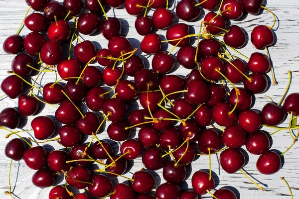 Lot Ripe Red Cherries Branches Lie Light Blue Wooden Table — Stockfoto