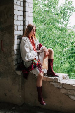 Ukrayna 'daki savaşın teması üzerine sanat çalışmaları. Ukraynalı hayal kırıklığına uğramış bir kadın, Rus ordusu tarafından bombalanan binanın penceresinde oturuyor..