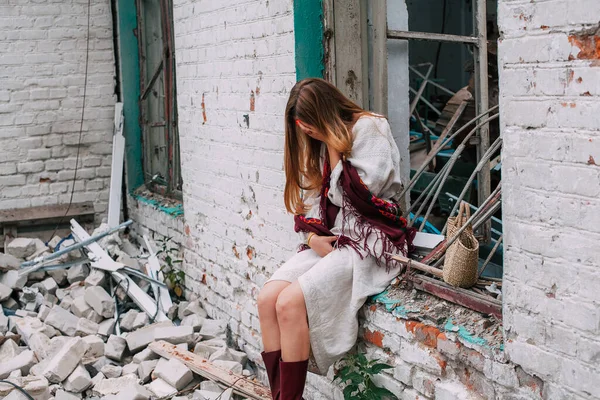 Ukrayna 'daki savaşın teması üzerine sanat çalışmaları. Ukraynalı hayal kırıklığına uğramış bir kadın, Rus ordusu tarafından bombalanan binanın penceresinde oturuyor..